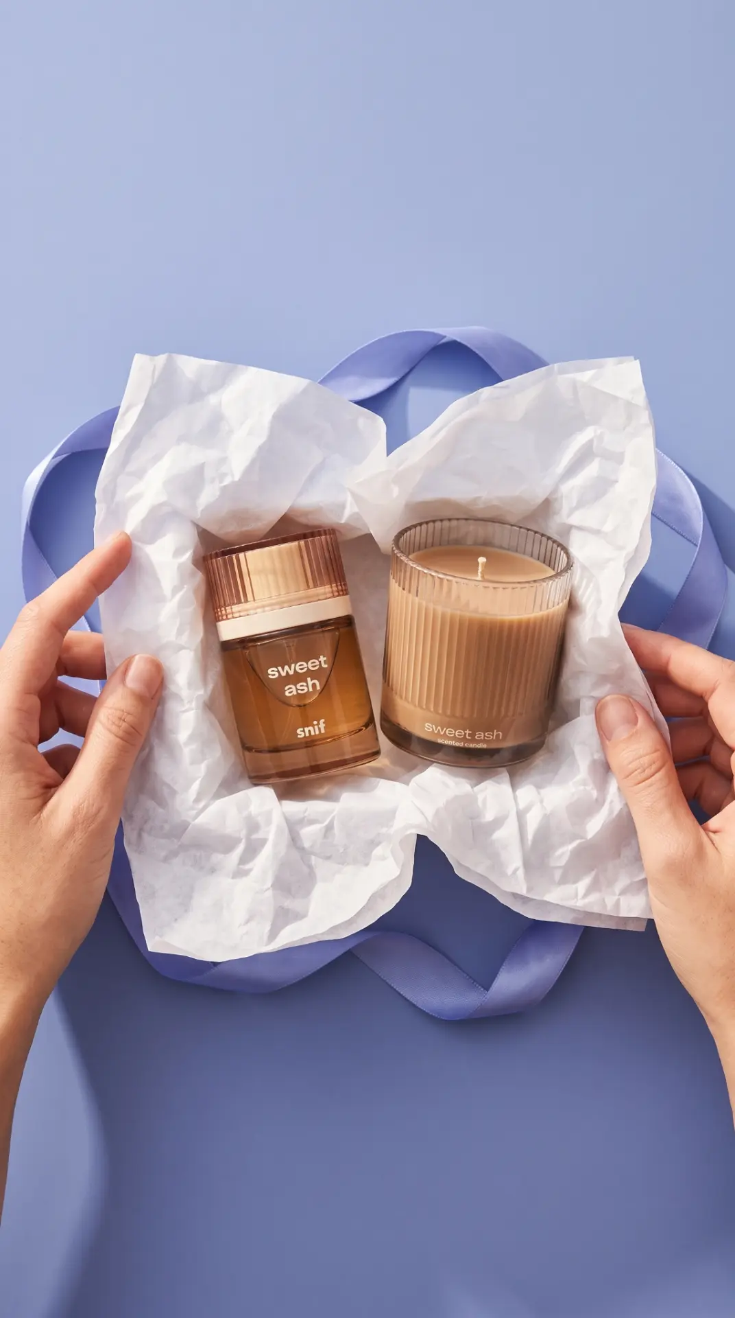 Fragrance gift-set campaign visual — fragrance and candle in tissue paper